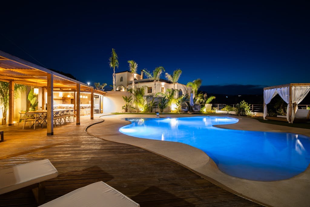 Experience luxury in a Mediterranean villa poolside at night, perfect for relaxation.